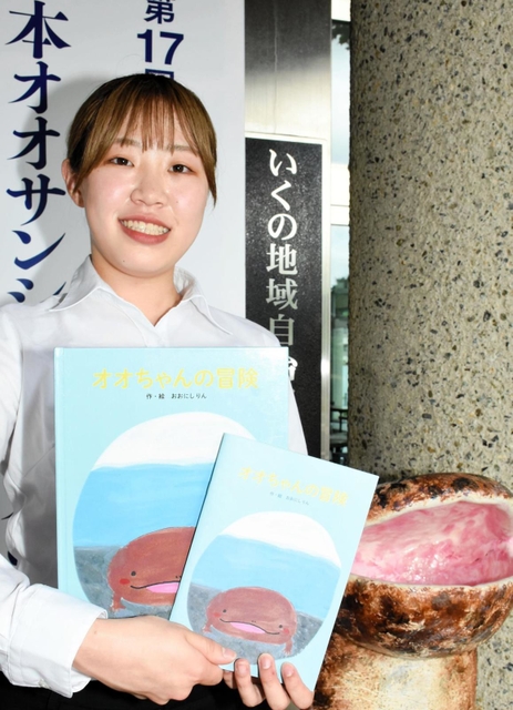 生野高校卒業生の大西凜さんは、オオサンショウウオを主人公にした絵本の製作などについて報告した＝生野マインホール