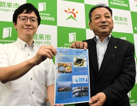 トラフグの陸上養殖に挑戦する中村峻さん（左）と藤岡勇市長＝朝来市役所