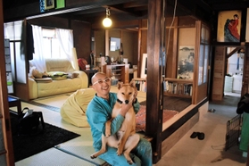 築８０年ほどの民家で愛犬と戯れるボッゾさん＝豊岡市竹野町竹野