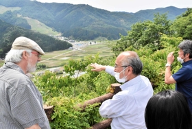 神鍋山の山頂からの景色を見る（左から）マティアス・フォークト教授と藤野一夫副学長ら＝神鍋山