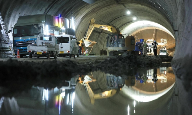 工事現場の水たまりに、作業員や車両などが映り込む＝新温泉町