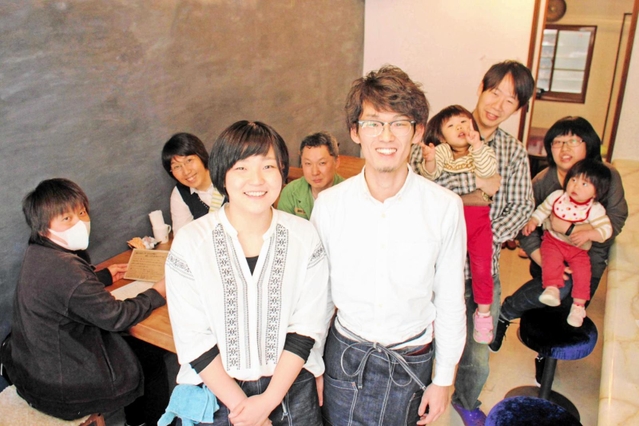 「ひととまる」の内覧会で住民らに囲まれる石丸佳佑さん、望さん夫婦＝豊岡市竹野町竹野