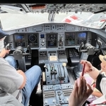 「ＡＴＲ４２－６００」の操縦席に座って体験する参加者たち。窓からは「ヤリスＷＲＣ」が見える＝但馬空港（撮影・岡本好太郎）