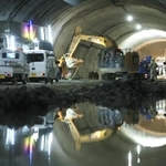 工事現場の水たまりに、作業員や車両などが映り込む＝新温泉町