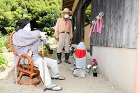 コロナ終息を願うかかしや地蔵と制作者の谷野祥敬さん＝朝来市納座