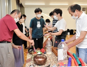 効果音に使用する楽器を選ぶ「毛帽子事務所」の高原綾子さん（左から２人目）や参加者ら＝豊岡市立野町