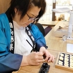 通常の木製の駒に文字入れをする天童市の職人（服部提供）