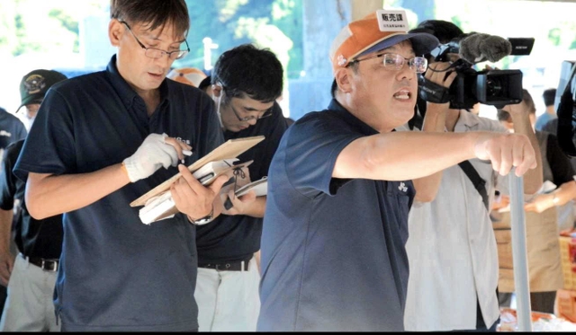 ベニズワイガニの初競りに臨む澤田敏幸さん。そばには帳面書きや札入れが控える＝香住漁港西港