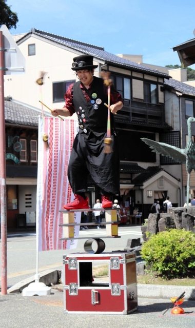 不安定な足場でバランス芸を繰り広げるパフォーマー＝豊岡市城崎町湯島