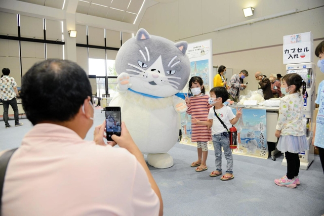 マルと記念撮影する親子連れ＝但馬空港