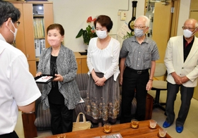 寄付金を手渡す保存会のメンバー＝城崎小