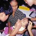 十分な医療が受けられないミャンマー貧困地区の幼児にポリオワクチンを投与する「懐」のメンバー（左）＝１９９８年１２月、ミャンマー国内