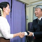 ミャンマー民主化指導者のアウンサンスーチー氏（左）と握手する高森拓也さん＝２０１１年１０月、ミャンマー国内