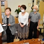 寄付金を手渡す保存会のメンバー＝城崎小