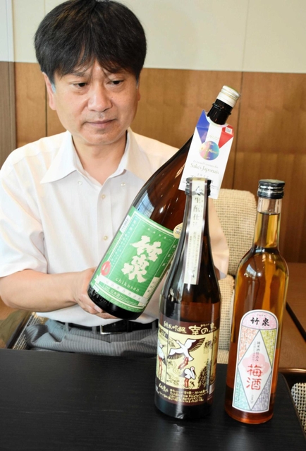 フランスのコンクールで最高賞を受けた「竹泉　純米　山田錦」などと田治米博貴社長＝朝来市役所