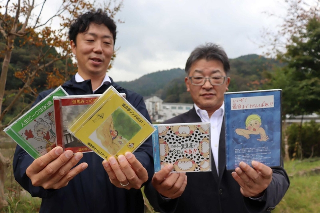 オリジナルＣＤを手にする作詞担当の久村謙藏さん（無駄信長、右）と、ギター兼ボーカルの勝地哲平さん（遊月亭いく藏）＝新温泉町井土