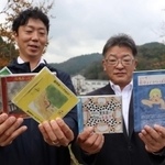 オリジナルＣＤを手にする作詞担当の久村謙藏さん（無駄信長、右）と、ギター兼ボーカルの勝地哲平さん（遊月亭いく藏）＝新温泉町井土