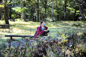 朝一番に園内の山野草を撮影する井上鈴奈さん＝高原植物園