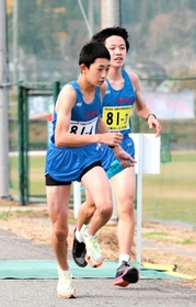 男子・豊岡北の３区森田正太郎選手（右）からたすきを受けて駆け出す４区溝尻大翔選手＝豊岡市日高町（撮影・長嶺麻子）