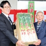 岩津ねぎ部会の荒川欣也部会長（右）から、ＪＡたじまの役員に丹精したネギが手渡された＝朝来市和田山町枚田