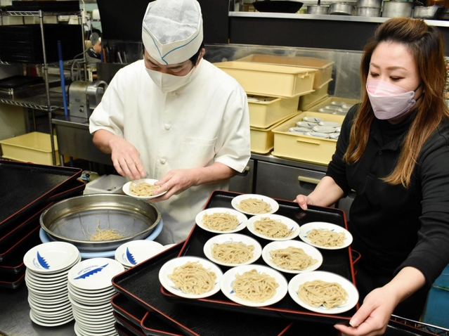 皿にそばを盛るそば店主ら＝豊岡市出石町内町
