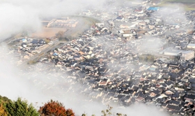 雲海の切れ間から見える市街地。薄茶色の壁や切妻屋根の建物が多く、出石のまちの特徴が一目で分かる＝豊岡市出石町伊木