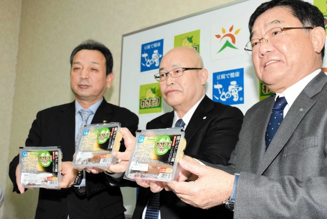 「わさビーフ風味タレ付き揚げだし豆腐」を手にする（右から）大豆工房の植田滋社長と山芳製菓の梅田登美雄専務、朝来市の藤岡勇市長＝朝来市伊由市場