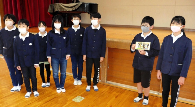 ６年生から引き継がれたアサガオの種を手にする５年生（右）＝新田小
