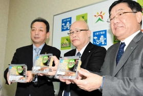 「わさビーフ風味タレ付き揚げだし豆腐」を手にする（右から）大豆工房の植田滋社長と山芳製菓の梅田登美雄専務、朝来市の藤岡勇市長＝朝来市伊由市場