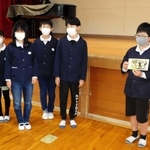 ６年生から引き継がれたアサガオの種を手にする５年生（右）＝新田小