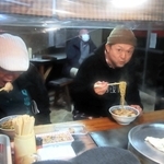 「松ちゃんラーメン」を味わう松本隆博さん（右）＝豊岡市日高町東芝