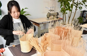 手編みで商品を仕上げる杞柳細工職人の山本香織さん＝豊岡市中央町