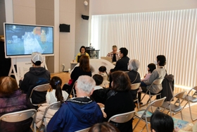 マルのはじまりの鐘の読み聞かせをする河合美智子さん、峯村純一さん＝やぶ市民交流広場（ＹＢ　ファブ）