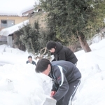 公会堂までの上り坂に積もった雪を取り除く生徒たち＝香美町村岡区板仕野