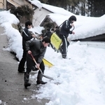公会堂までの上り坂に積もった雪を取り除く生徒たち＝香美町村岡区板仕野