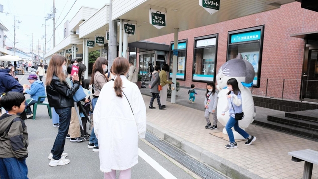 マルがステージに立つと、多くのファンが囲み、記念撮影を楽しんだ＝豊岡市中央町、カバンストリート