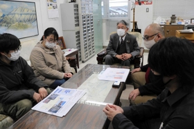 登日幸治但馬県民局長（中央、奥）に周遊モデルコース案を示す学生ら＝県豊岡総合庁舎