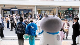 マルがステージに立つと、多くのファンが囲み、記念撮影を楽しんだ＝豊岡市中央町、カバンストリート