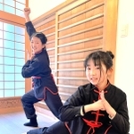 カンフーのポーズをとる小原百恵さん（左）と、妹の恵子さん＝豊岡市出石町