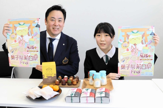 デザインしたポスターを手にする荒木りこさん（右）と角谷隆政実行委員長＝豊岡市役所