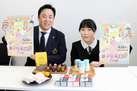 デザインしたポスターを手にする荒木りこさん（右）と角谷隆政実行委員長＝豊岡市役所