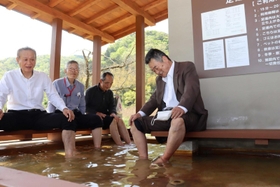 白さぎの湯に足を漬ける地域の人たち＝新温泉町七釜