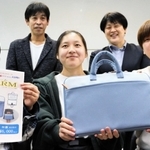 商品開発したタブレットケースを手に持つ川溿江梨さん（前列中央）ら＝豊岡総合高