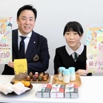 デザインしたポスターを手にする荒木りこさん（右）と角谷隆政実行委員長＝豊岡市役所