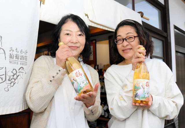 豊岡市産ブドウを使った白ワイン「こうのとりわいん」のラベルを手がけた河合美智子さん（右）、成相淑子さん＝豊岡市出石町魚屋
