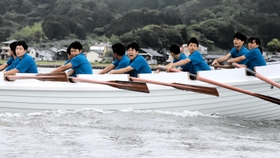 息を合わせて力強くオールをこぐ生徒たち＝香住湾