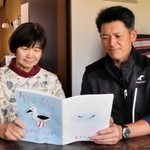 絵本を読む青山直也さん（右）と川田恵美子さん＝豊岡市日高町万劫