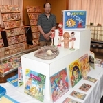漫画週刊誌や関連グッズなどの展示と天野浩次さん＝ヒメハナ公園