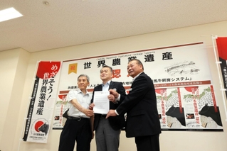 世界農業遺産の認定通知書を掲げる（左から）新温泉町の西村銀三町長、香美町の浜上勇人町長、ＪＡたじまの太田垣哲夫組合長＝香美町役場