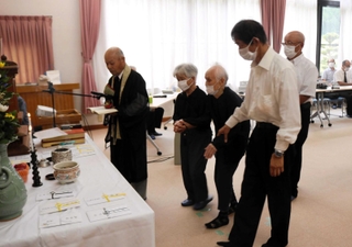 焼香をする生還した元団員やその家族たち＝豊岡市但東町久畑